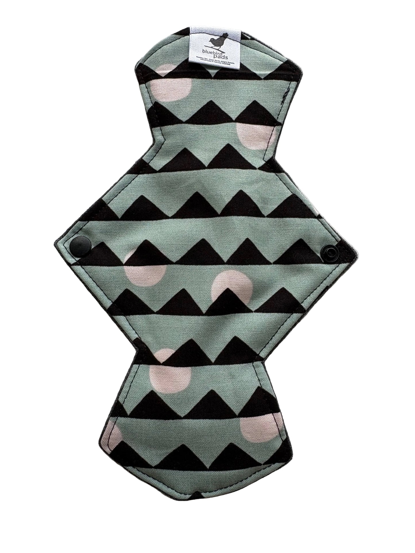 Reusable menstrual pad with geometric pattern on a light gray background