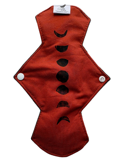 Brick Orange cloth pad with black phases of the moon stamp design 