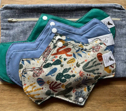 An assortment of feminine pads and Protectors with different designs and colors 